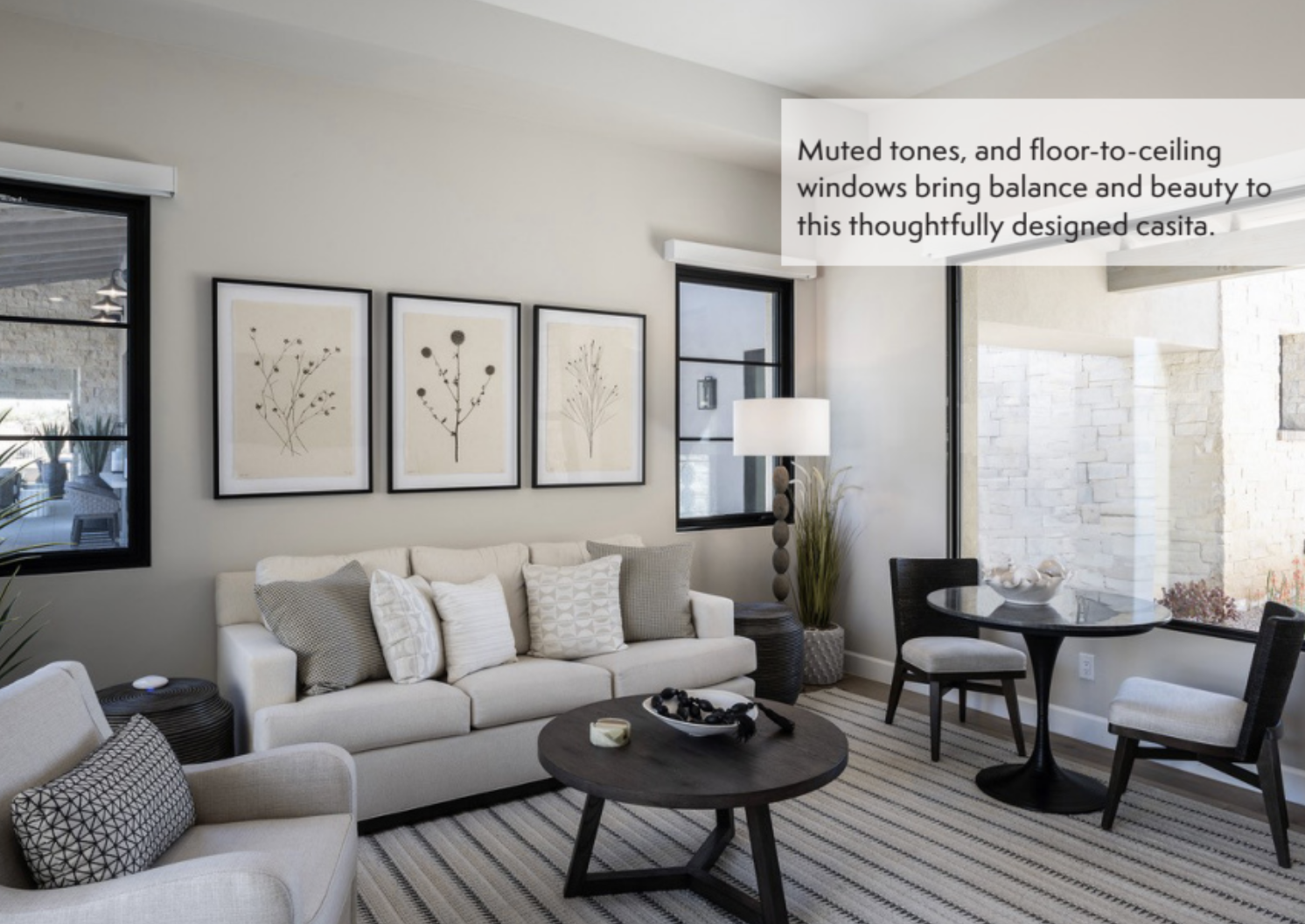 Modern living room featuring neutral tones, minimalist décor, and floor-to-ceiling windows that fill the space with natural light and balance.